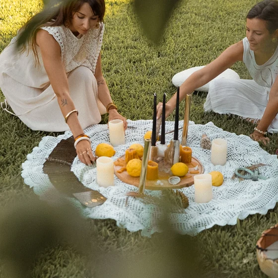 Un rituel en cercle, bougies et fruits posés sur une nappe